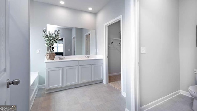 bathroom featuring vanity, toilet, and a tub