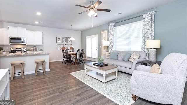 living room featuring dark hardwood / wood-style floors and ceiling fan