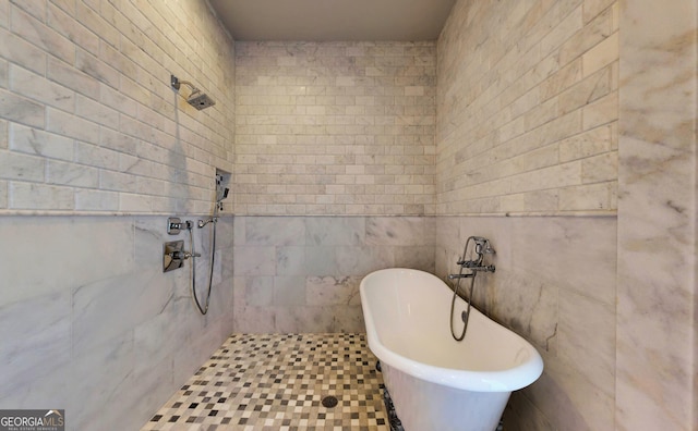 bathroom featuring a bath, tile patterned floors, and tile walls