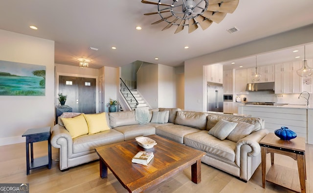 living room with sink and light hardwood / wood-style flooring