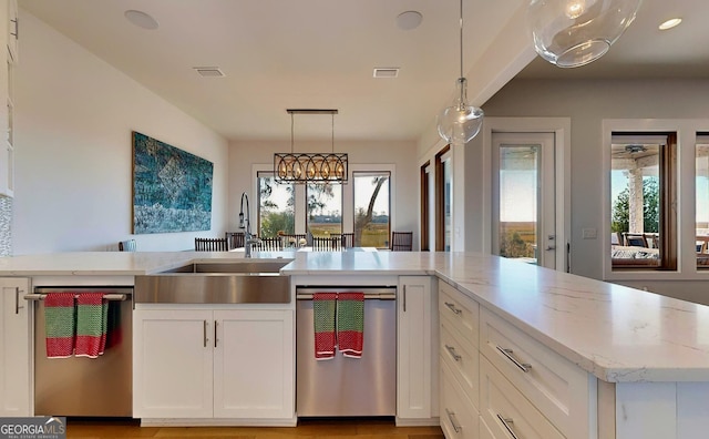 kitchen featuring white cabinets, a healthy amount of sunlight, sink, and pendant lighting