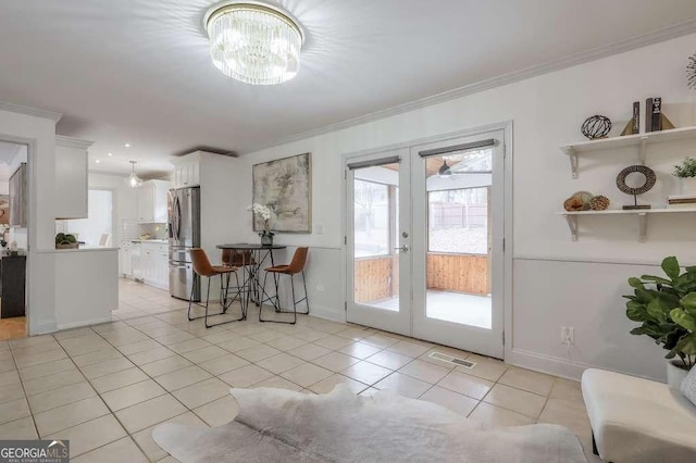 tiled dining space with crown molding, french doors, and a chandelier