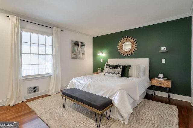 bedroom featuring crown molding and hardwood / wood-style flooring