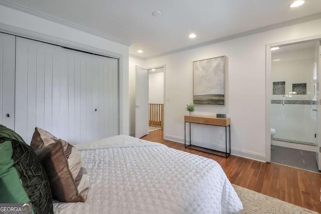 bedroom with connected bathroom, dark hardwood / wood-style flooring, and ornamental molding