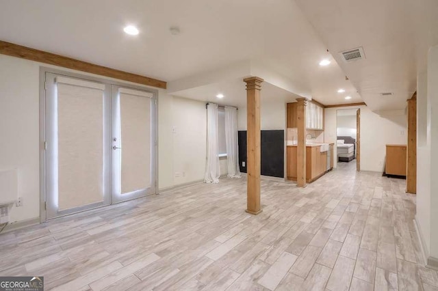 basement with light hardwood / wood-style flooring and sink