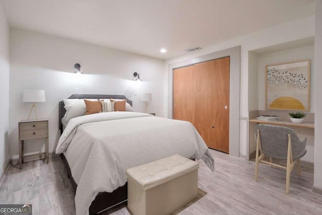 bedroom with a closet and light hardwood / wood-style flooring