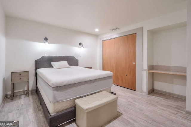 bedroom with light hardwood / wood-style flooring and a closet