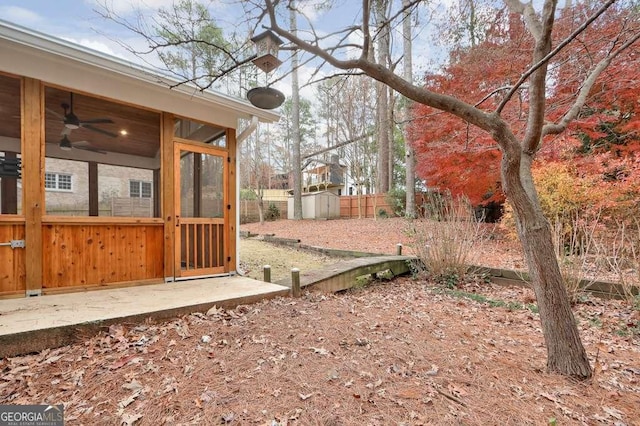 view of yard with a shed and ceiling fan