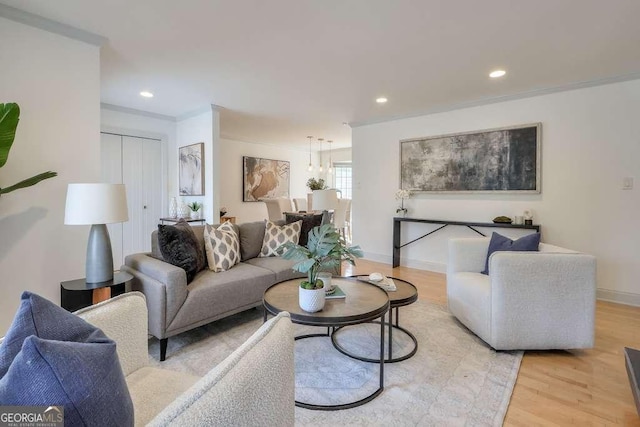 living room featuring light wood-type flooring and crown molding