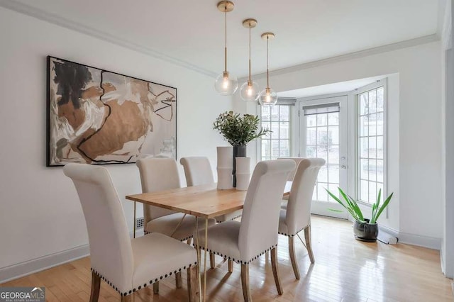 dining area with french doors, light hardwood / wood-style flooring, and crown molding