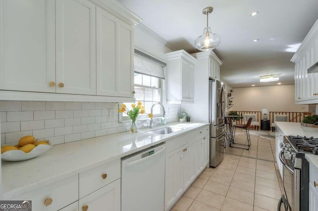 kitchen with sink, decorative light fixtures, light tile patterned flooring, white cabinetry, and stainless steel appliances