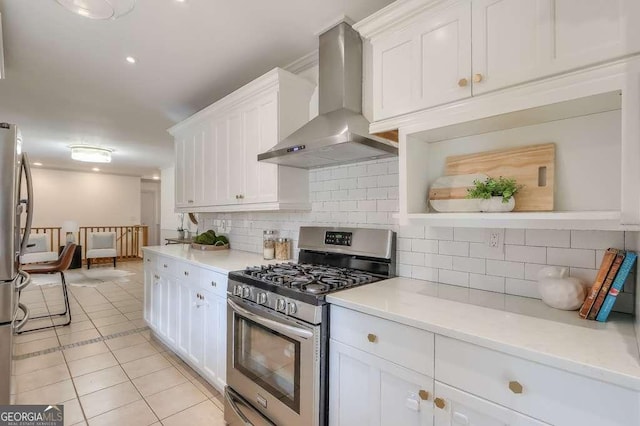 kitchen featuring white cabinets, light tile patterned floors, wall chimney range hood, and appliances with stainless steel finishes