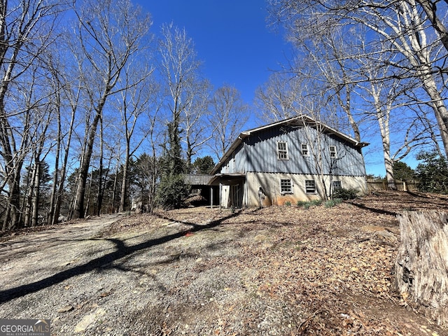 view of side of home featuring dirt driveway