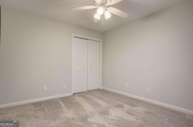 unfurnished bedroom with ceiling fan, a closet, and light carpet