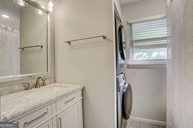 bathroom featuring vanity and stacked washer / dryer