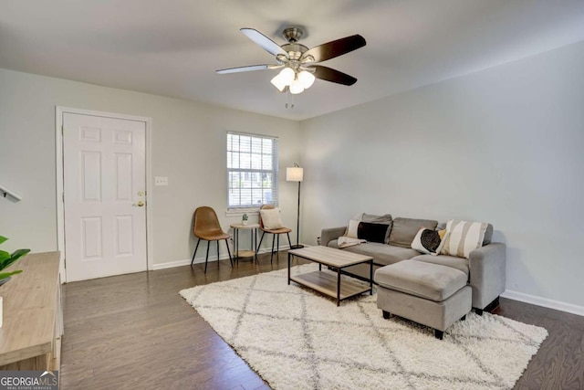 living room featuring ceiling fan and dark hardwood / wood-style flooring