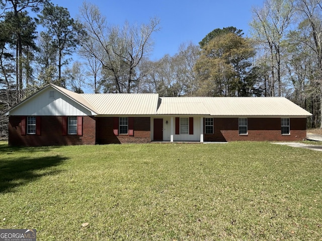 ranch-style home featuring metal roof, brick siding, and a front lawn