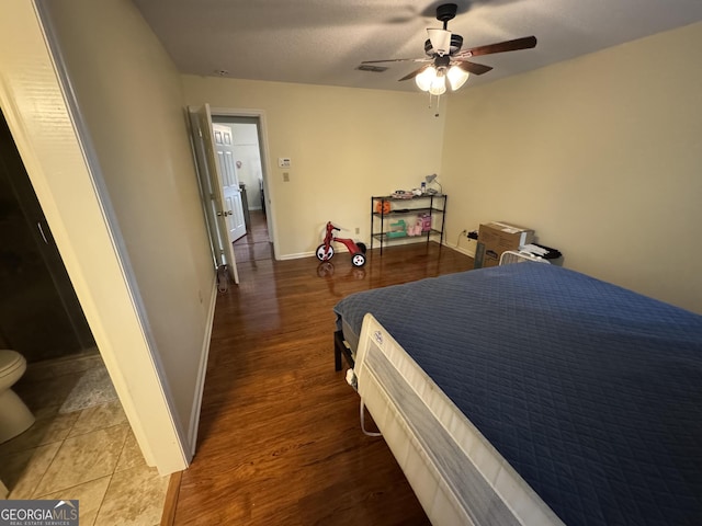 bedroom featuring ceiling fan, baseboards, and wood finished floors