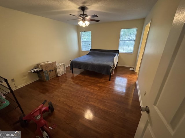 bedroom with ceiling fan, baseboards, a textured ceiling, and wood finished floors