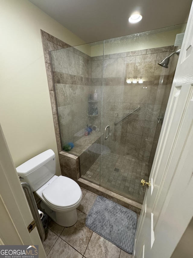 full bath with tile patterned flooring, toilet, and a stall shower