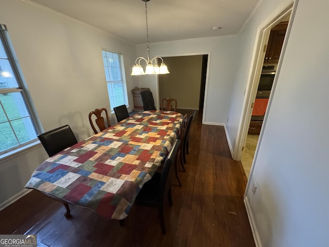 dining area with ornamental molding, wood finished floors, and a chandelier