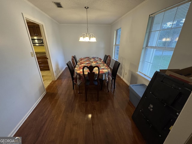 dining area with dark wood-style floors, visible vents, a chandelier, and a textured ceiling