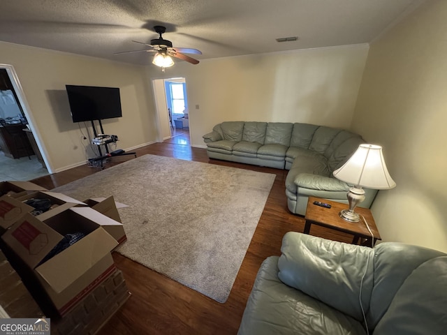 living room with visible vents, a ceiling fan, and wood finished floors