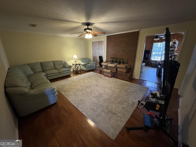 living area with visible vents, a textured ceiling, and wood finished floors