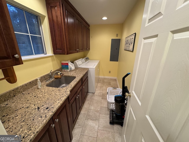 clothes washing area featuring electric panel, a sink, cabinet space, baseboards, and washing machine and clothes dryer