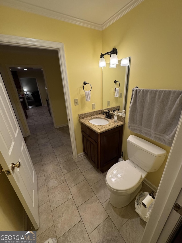 half bathroom featuring baseboards, toilet, ornamental molding, tile patterned floors, and vanity