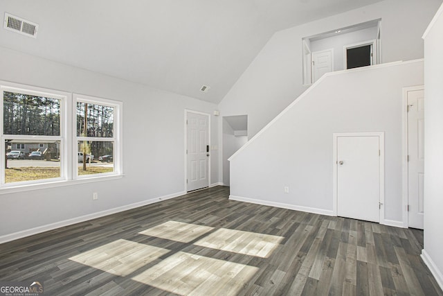 unfurnished living room with high vaulted ceiling and dark wood-type flooring