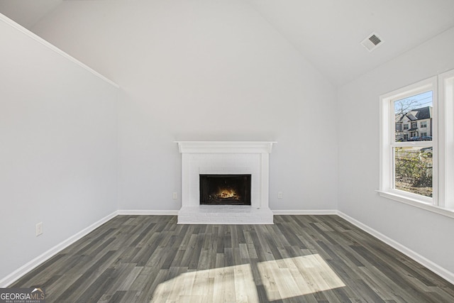 unfurnished living room with a fireplace, vaulted ceiling, and dark wood-type flooring