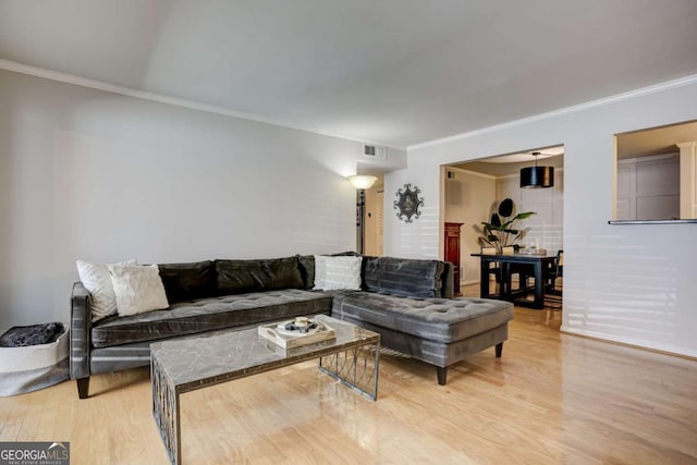 living room with light wood-type flooring and crown molding