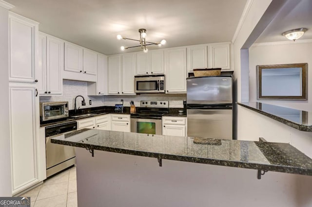 kitchen featuring dark stone countertops, sink, white cabinets, and stainless steel appliances