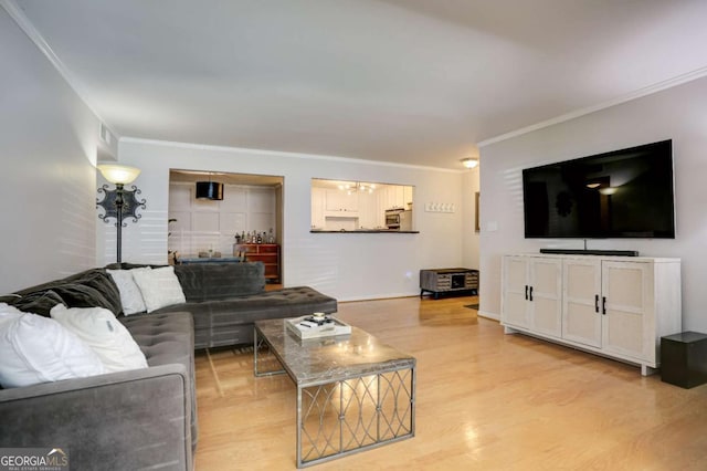 living room with light wood-type flooring and ornamental molding