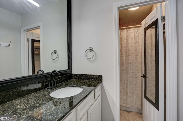 bathroom featuring tile patterned flooring, a shower with curtain, and vanity