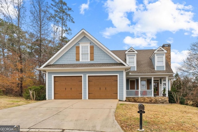 view of front of property with a front lawn, covered porch, and a garage