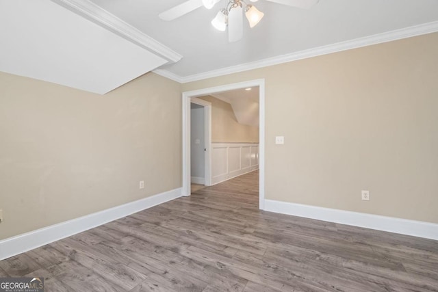 spare room featuring hardwood / wood-style flooring, ceiling fan, and ornamental molding