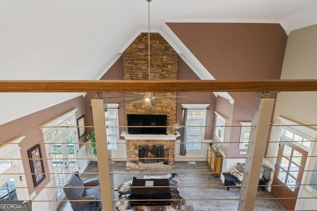 living room with high vaulted ceiling and a stone fireplace