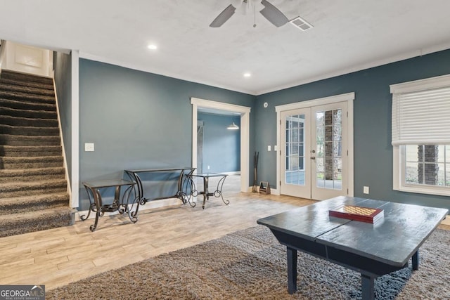 living room with hardwood / wood-style flooring, ceiling fan, and french doors