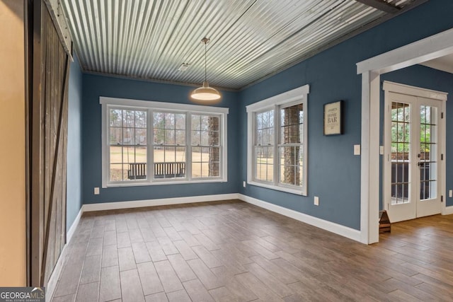 unfurnished dining area featuring hardwood / wood-style floors, a healthy amount of sunlight, and french doors