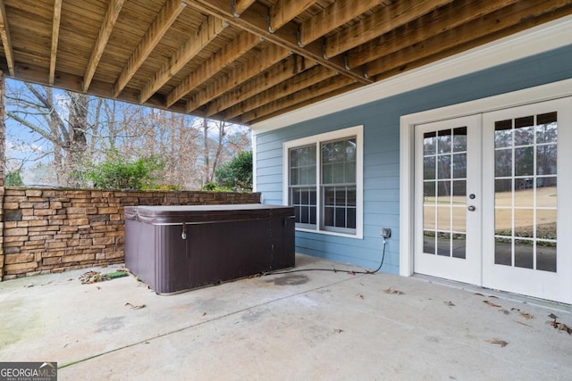 view of patio with a hot tub and french doors