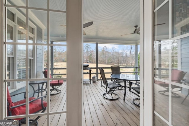 sunroom / solarium featuring ceiling fan