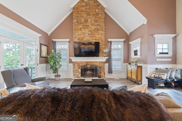 living room with ornamental molding, hardwood / wood-style flooring, high vaulted ceiling, and a healthy amount of sunlight