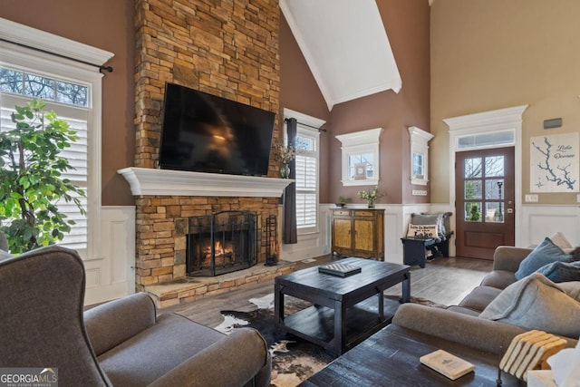 living room with hardwood / wood-style floors, high vaulted ceiling, and a wealth of natural light