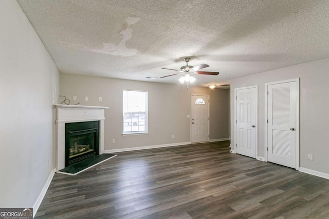 unfurnished living room with dark hardwood / wood-style floors, ceiling fan, and a textured ceiling