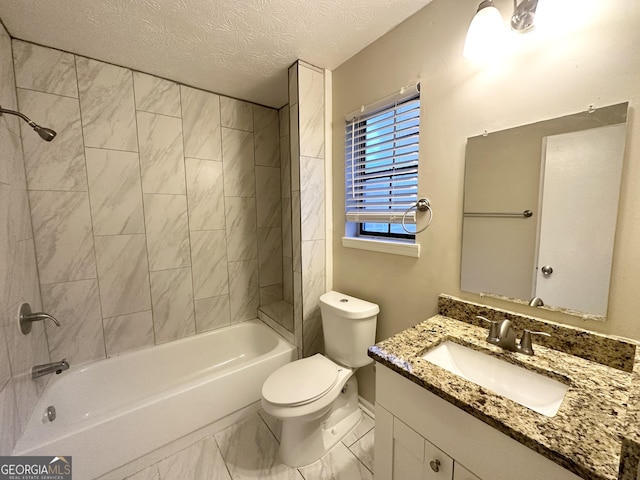 full bathroom with toilet, vanity, a textured ceiling, and tiled shower / bath combo