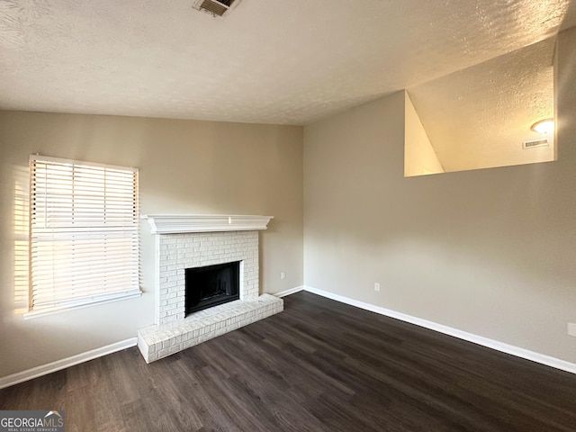 unfurnished living room with a textured ceiling, a fireplace, dark hardwood / wood-style floors, and lofted ceiling