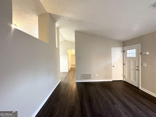 interior space featuring a textured ceiling, dark hardwood / wood-style floors, and lofted ceiling