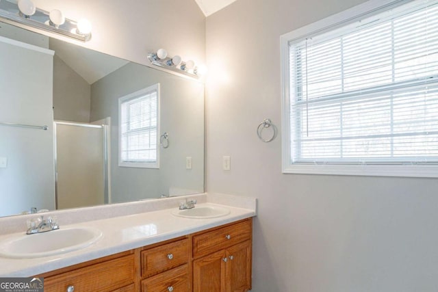 bathroom with vanity, a shower with door, and plenty of natural light